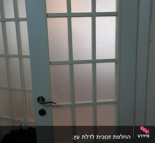 דלת זכוכית עם חלונות מחולקים במסגרת לבנה